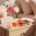 Load image into Gallery viewer, Prettier in Pink nighttime sleep glasses styled on coffee table - lifestyle shot