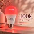 Load image into Gallery viewer, A Dream Walker LED light bulb glowing with a deep red light, shown on a wooden surface with a warm, softly lit background and text reading '1100K Deep red light'.
